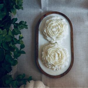 Flower-shaped candles on a wooden tray